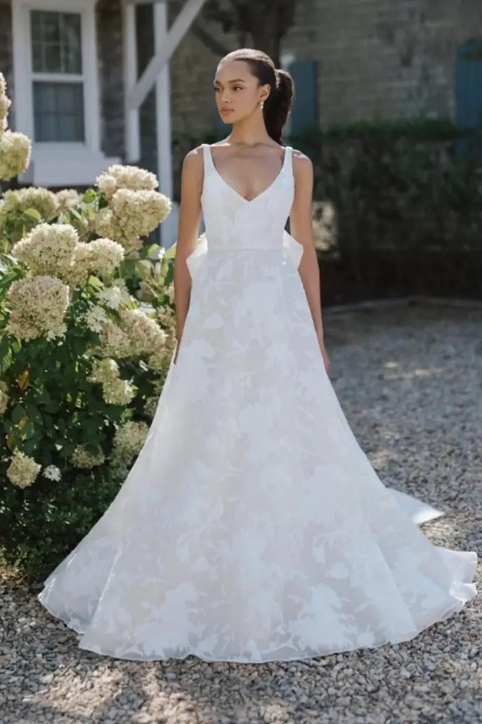 Model wearing a white beaded style gown